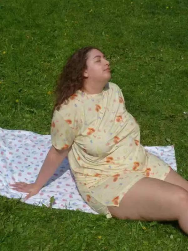 Woman relaxing on grass in yellow pajamas