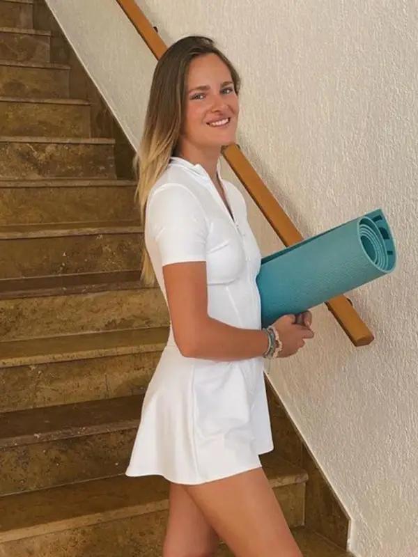Model with yoga mat in white jumpsuit
