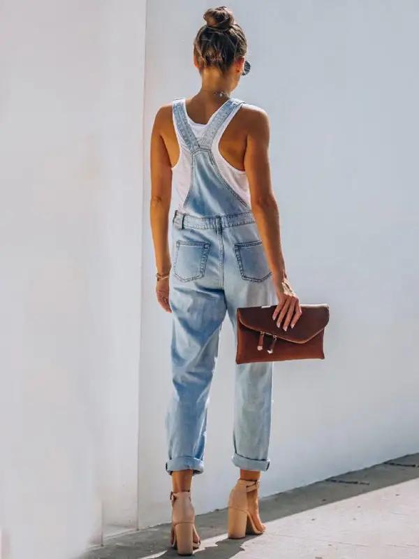 Back view of washed ripped blue overalls jeans, rolled cuffs