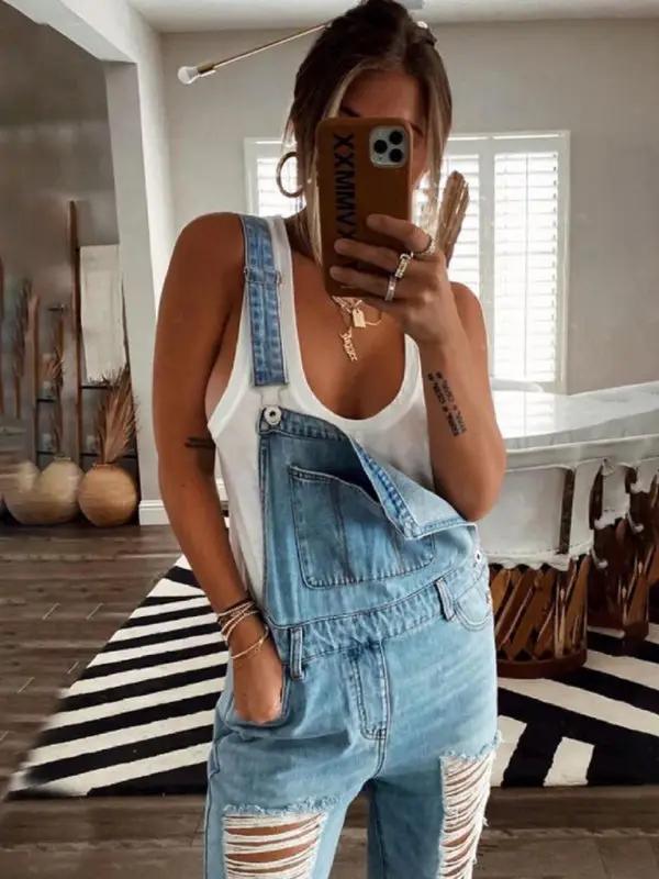 Woman in washed ripped blue overalls jeans, mirror selfie