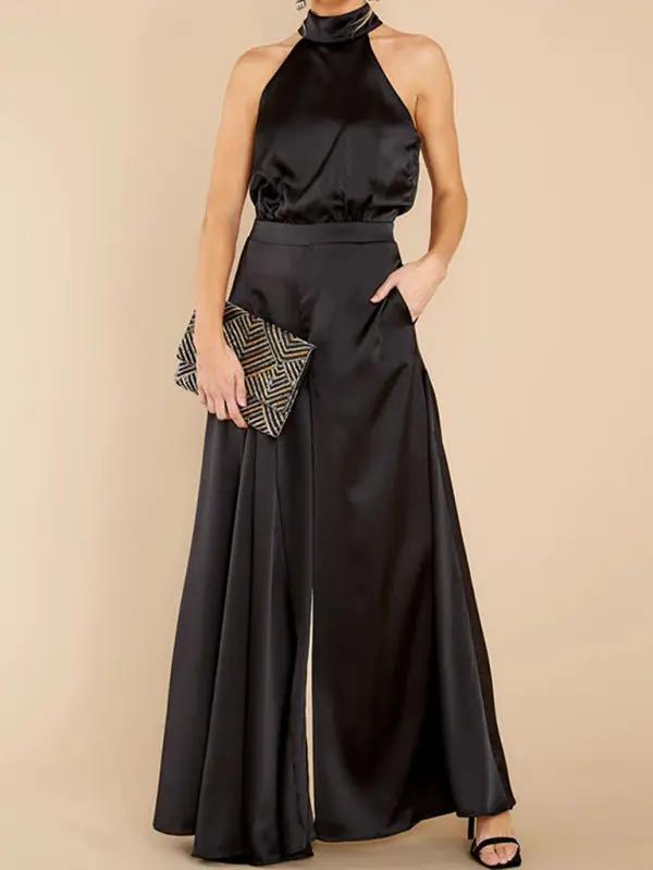 Black halter-neck wide-leg jumpsuit with clutch, front view