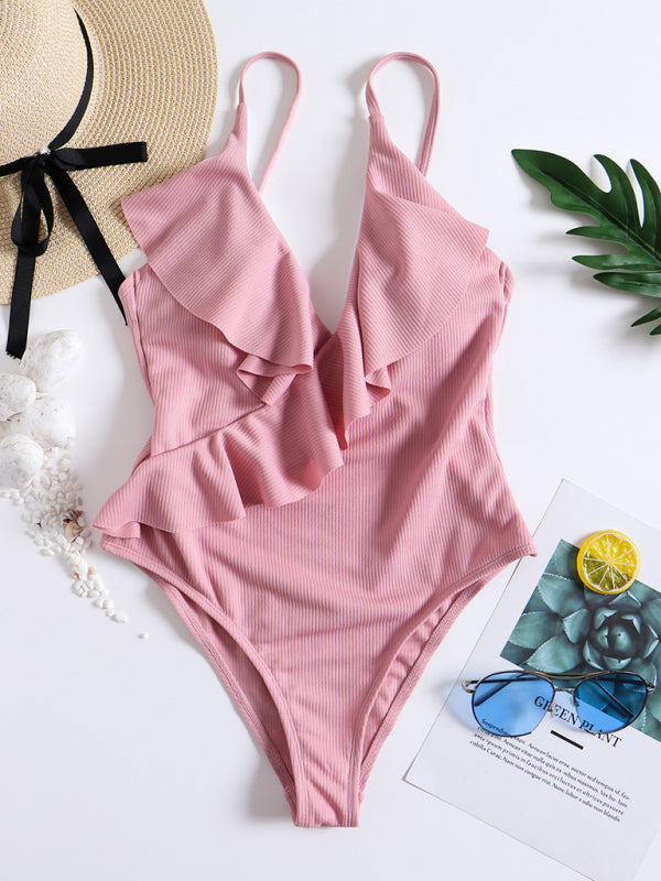 Pink ruffled one-piece swimsuit with accessories