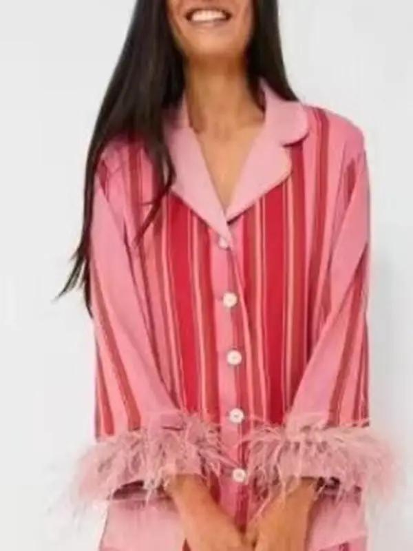 Model wearing pink striped feather-trimmed pajamas, smiling