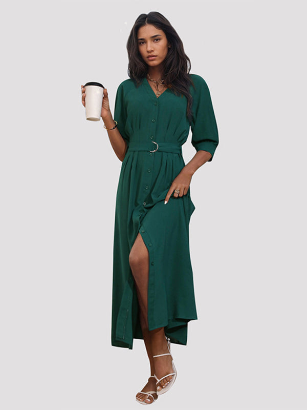 Woman in green V-neck mid-sleeve dress holding a cup