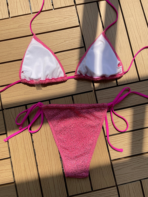 Pink and white strap triangle bikini on wooden surface