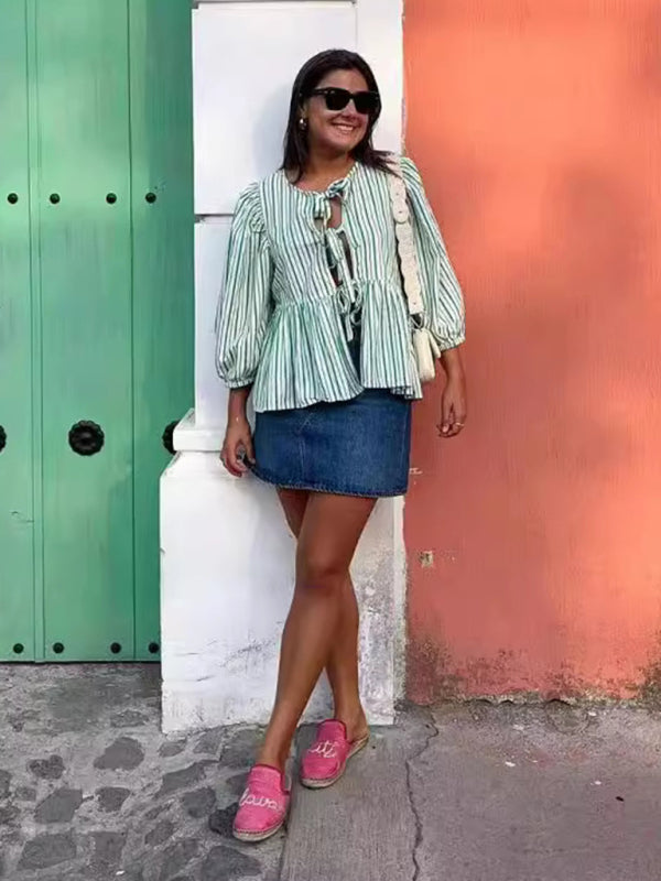 Woman in striped blouse and denim skirt outdoors