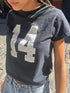 Person wearing black distressed T-shirt with number 14