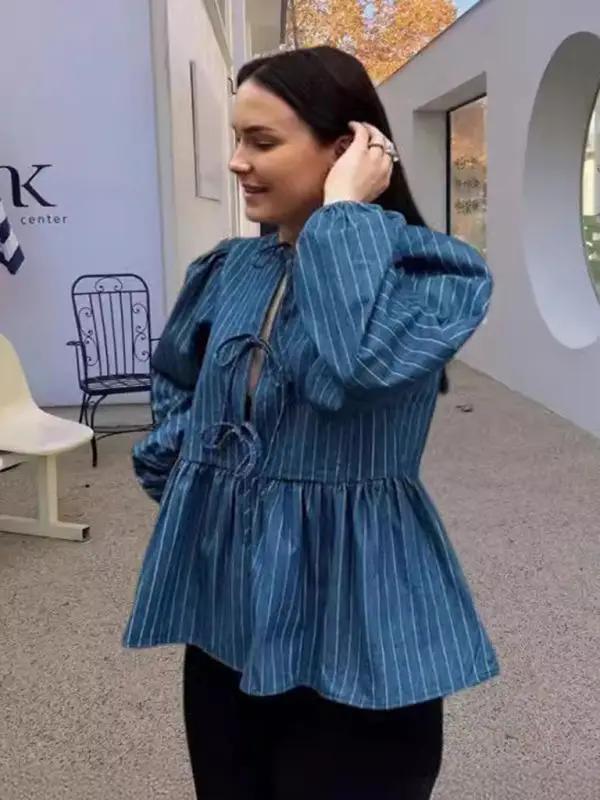 Side view of a woman in a blue striped lace-up loose top