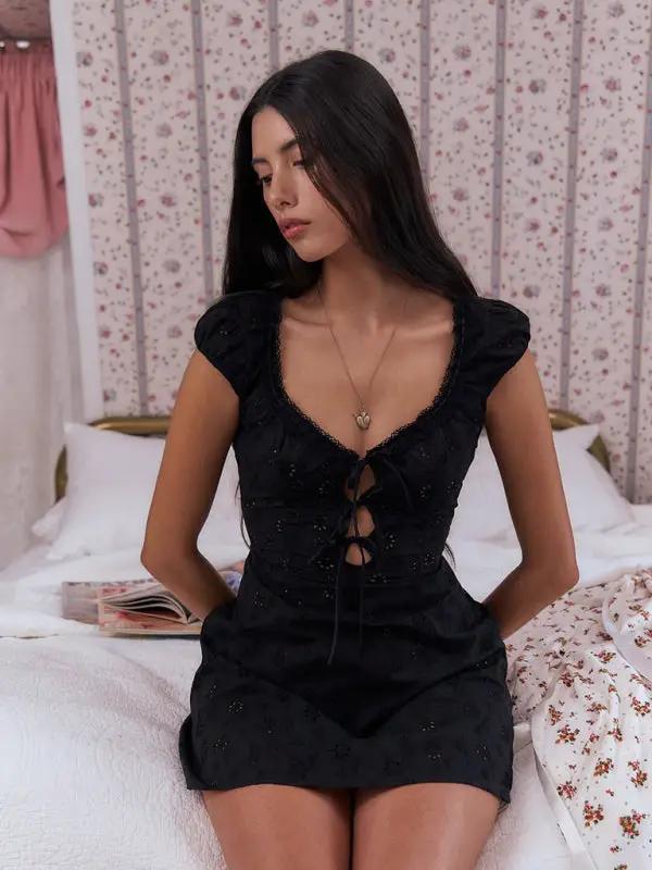 Black lace dress, seated with hands behind back