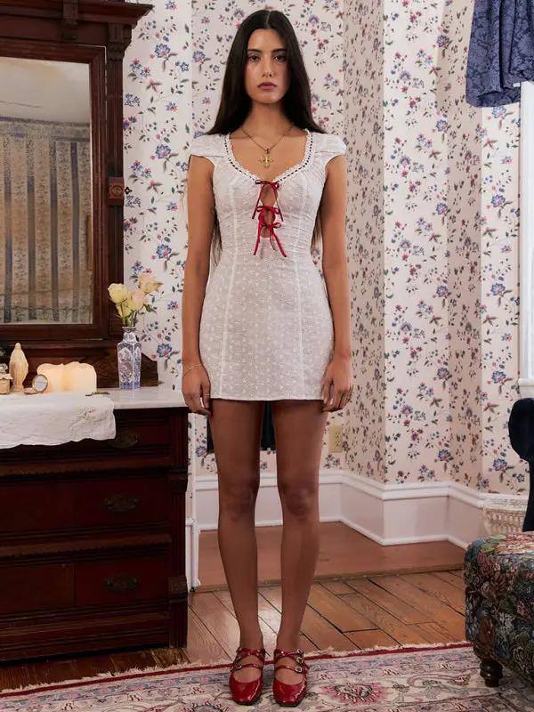 Front view of white lace dress with red ribbon accent