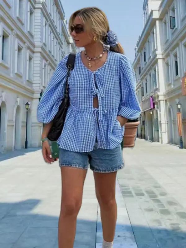 Blue gingham puff sleeve shirt with denim shorts outdoors