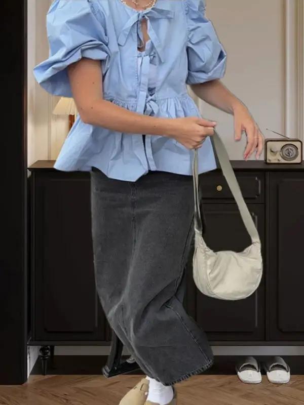 Light blue puff sleeve shirt with black skirt and handbag