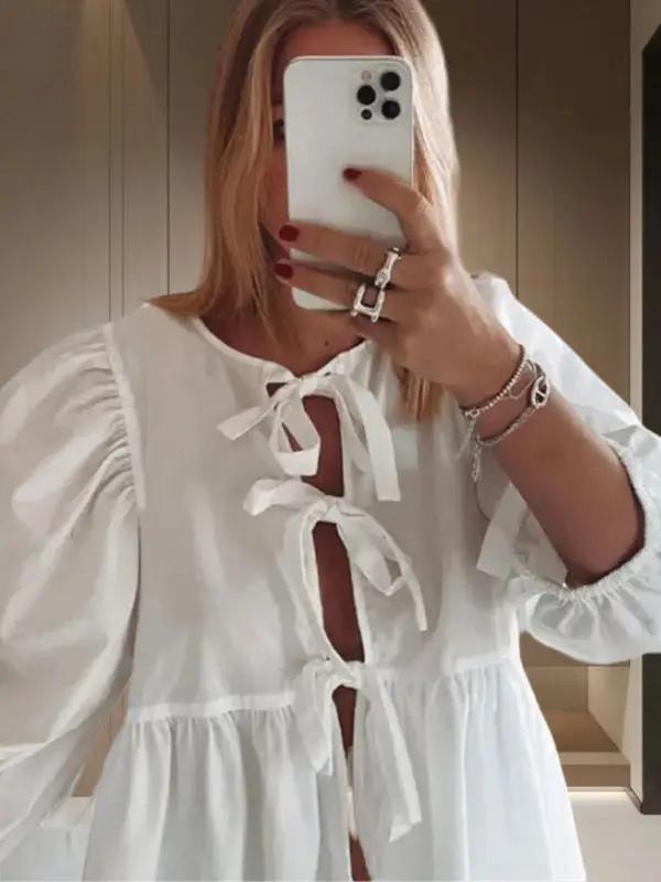Close-up of white puff sleeve shirt with strappy front design