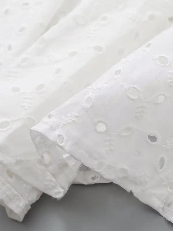 Close-up of embroidered fabric on white dress