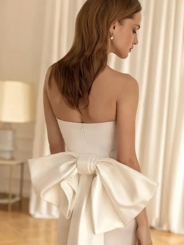 Close-up of white dress featuring a large bow at the back