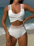 Pink swimsuit with rainbow ribbon details on a patterned rug