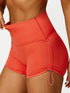Orange high-waisted yoga shorts with drawstring