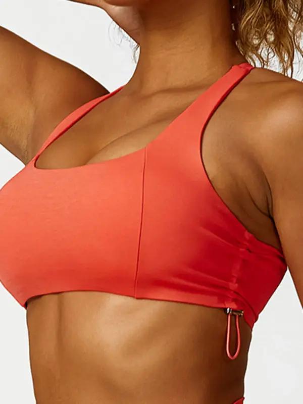Close-up of orange sports bra with drawstring detail