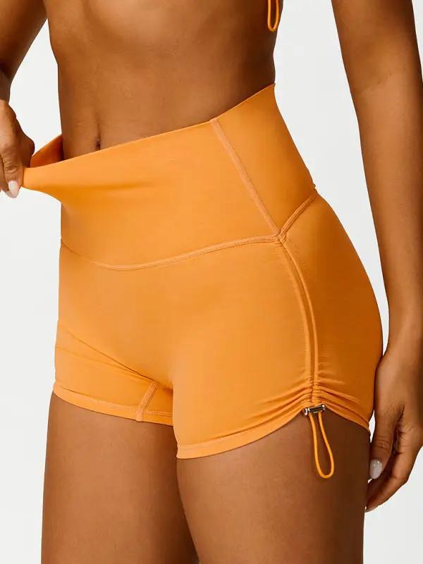 Orange high-waisted yoga shorts with drawstring