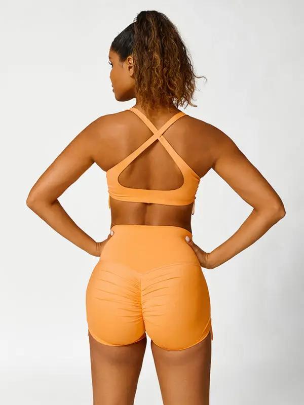 Back view of orange activewear set, crisscross straps