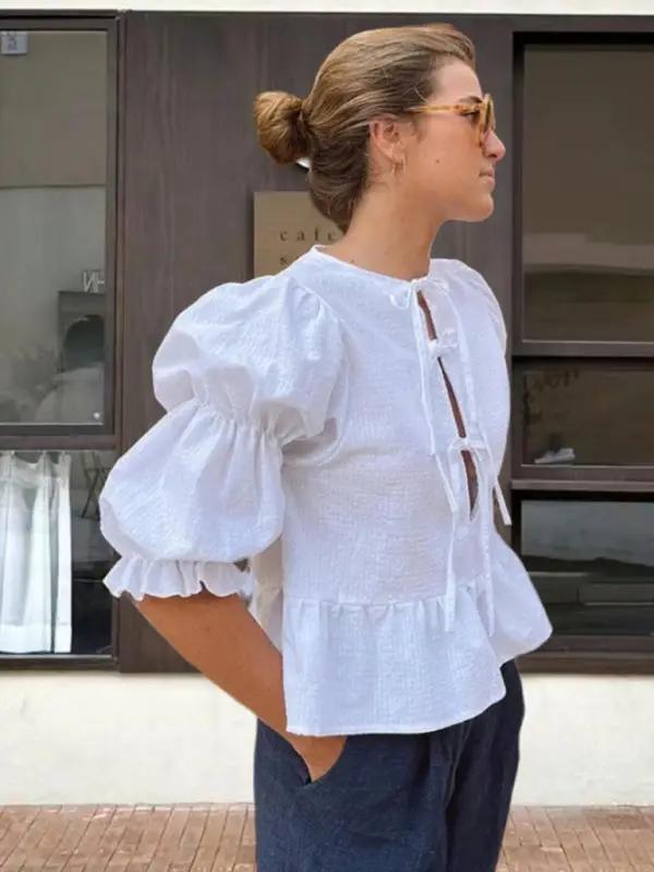 Side view of white puff sleeve blouse with tie detail