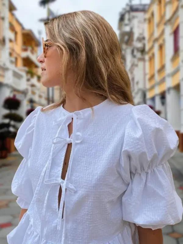 Close-up of white puff sleeve blouse with tie detail