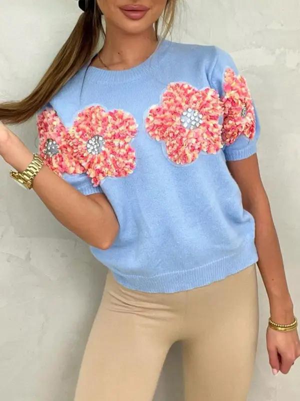 Blue sweater with contrasting flower design, round neck.