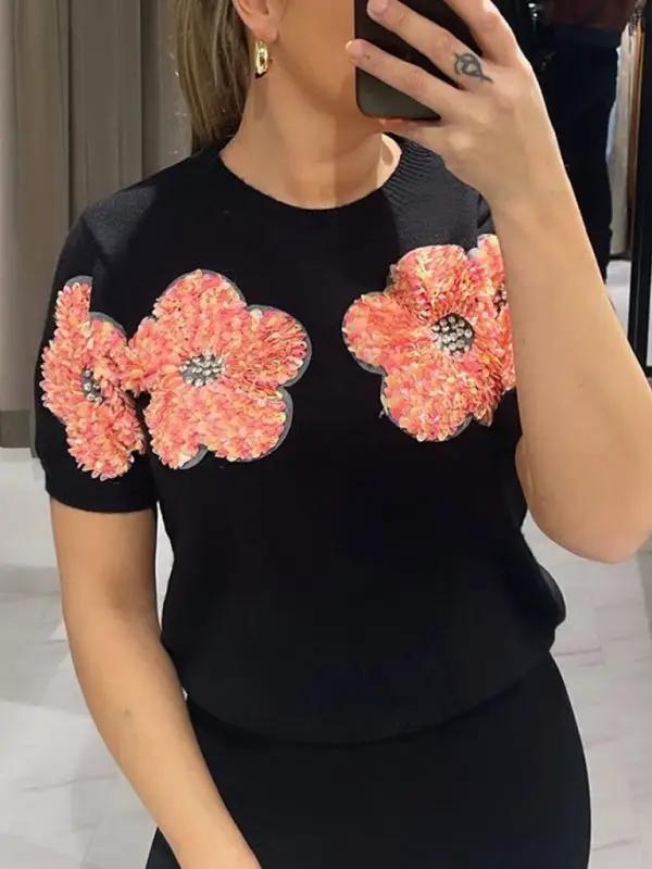Black sweater with pink floral design, round neck.