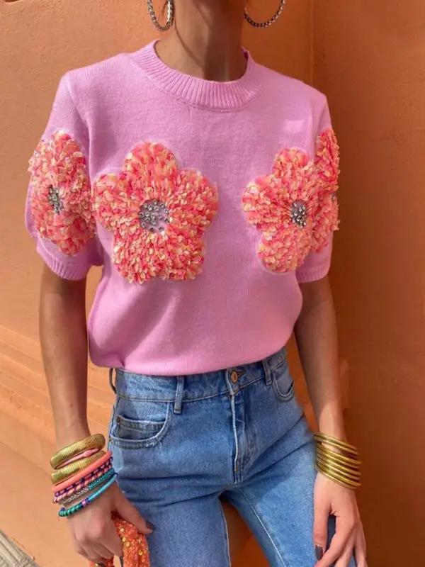 Sweet pink sweater with flower design, styled with jeans.