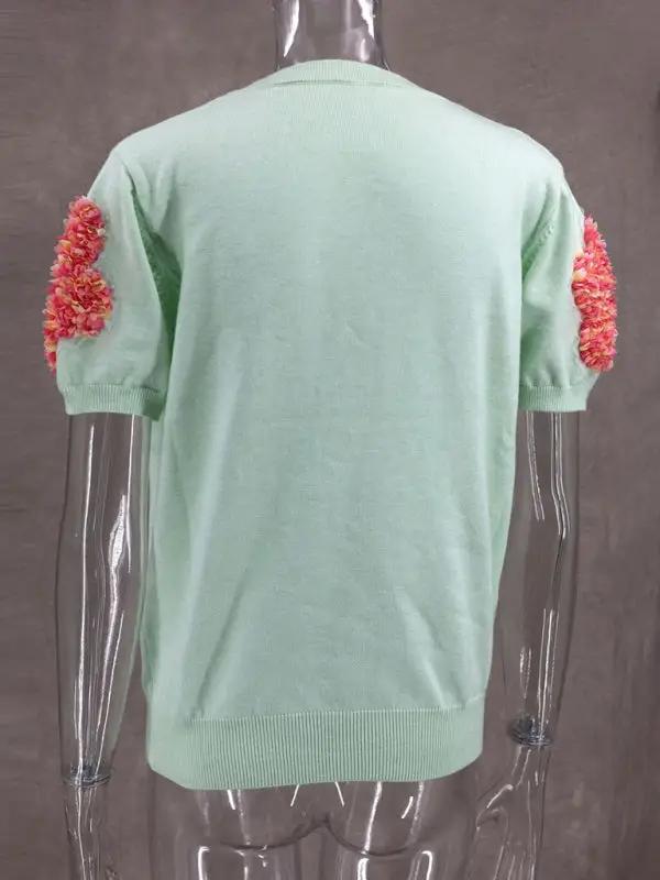Back view of sweet pink sweater with floral accents.