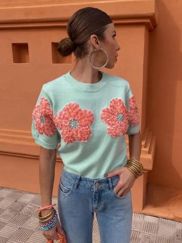 Side view of sweet pink sweater with contrasting flowers.
