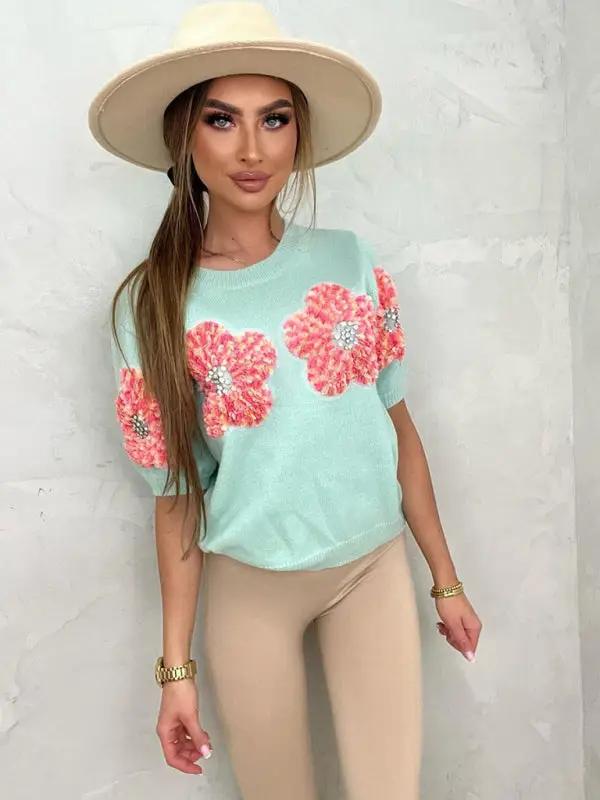 Model wearing sweet pink sweater with flower design.