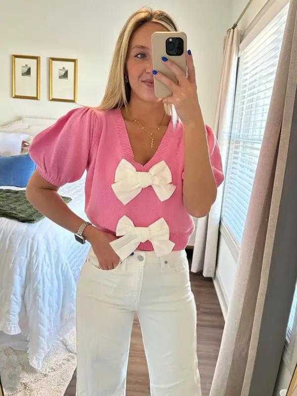 Pink V-neck sweater with white double bows, short sleeves