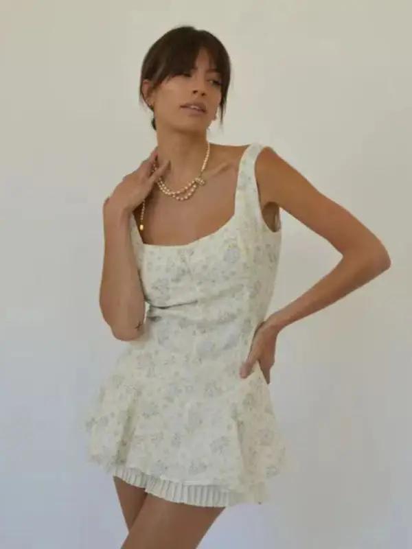 Model wearing floral hem pleated suspender dress