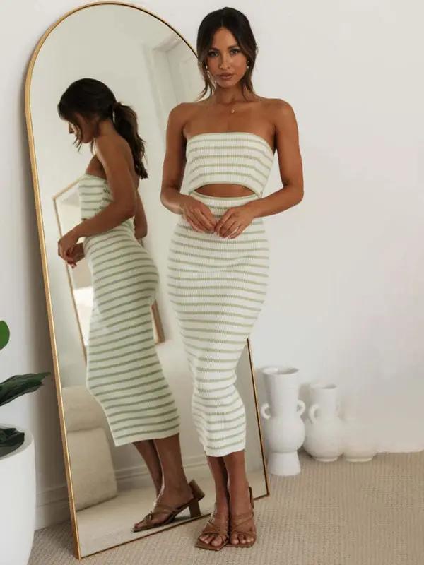 Striped tube top dress in front of mirror indoors