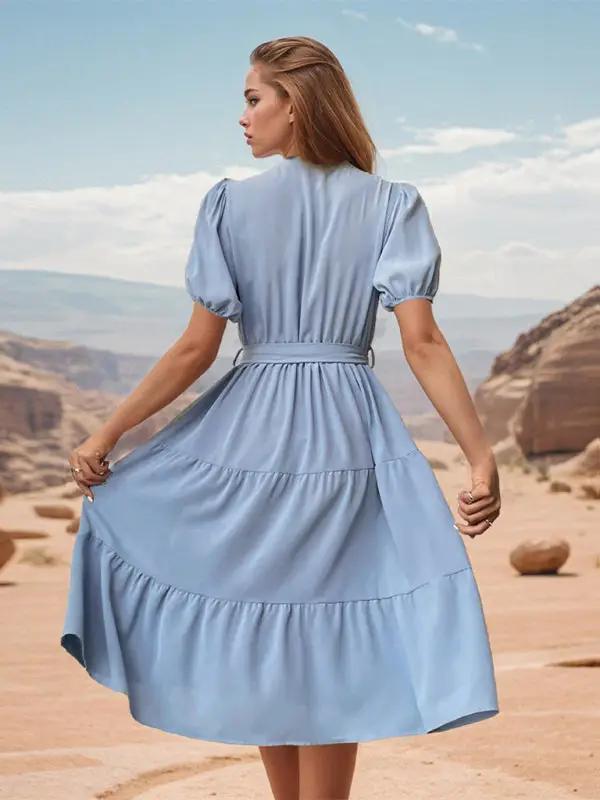 Back view of blue pleated midi dress with puff sleeves