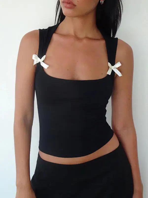 Black vest with white bow detail, close-up