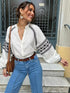 Woman wearing a cross-stitch contrasting shirt with jeans