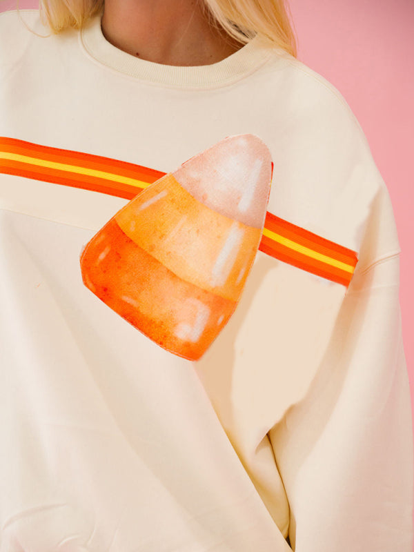 Close-up of candy corn design on cream sweatshirt