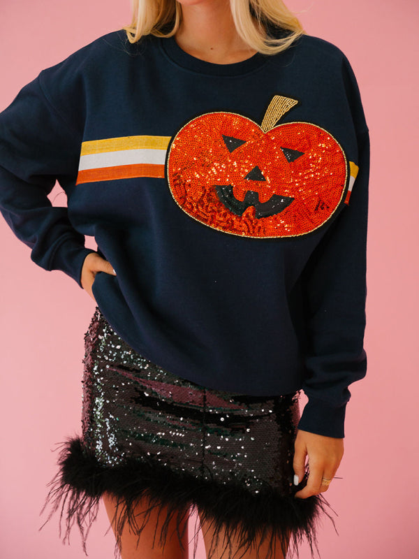 Close-up of sequined pumpkin on navy sweatshirt
