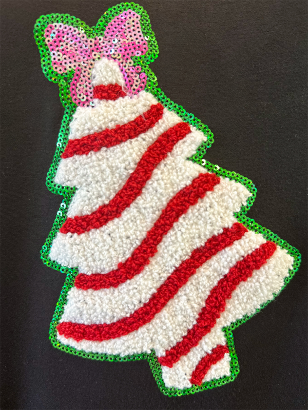 Close-up of sequin Christmas tree decoration on sweatshirt