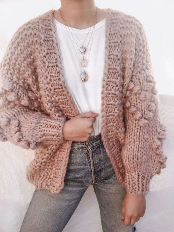 a woman wearing a white shirt and a pink cardigan