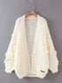 a white sweater hanging on a hanger