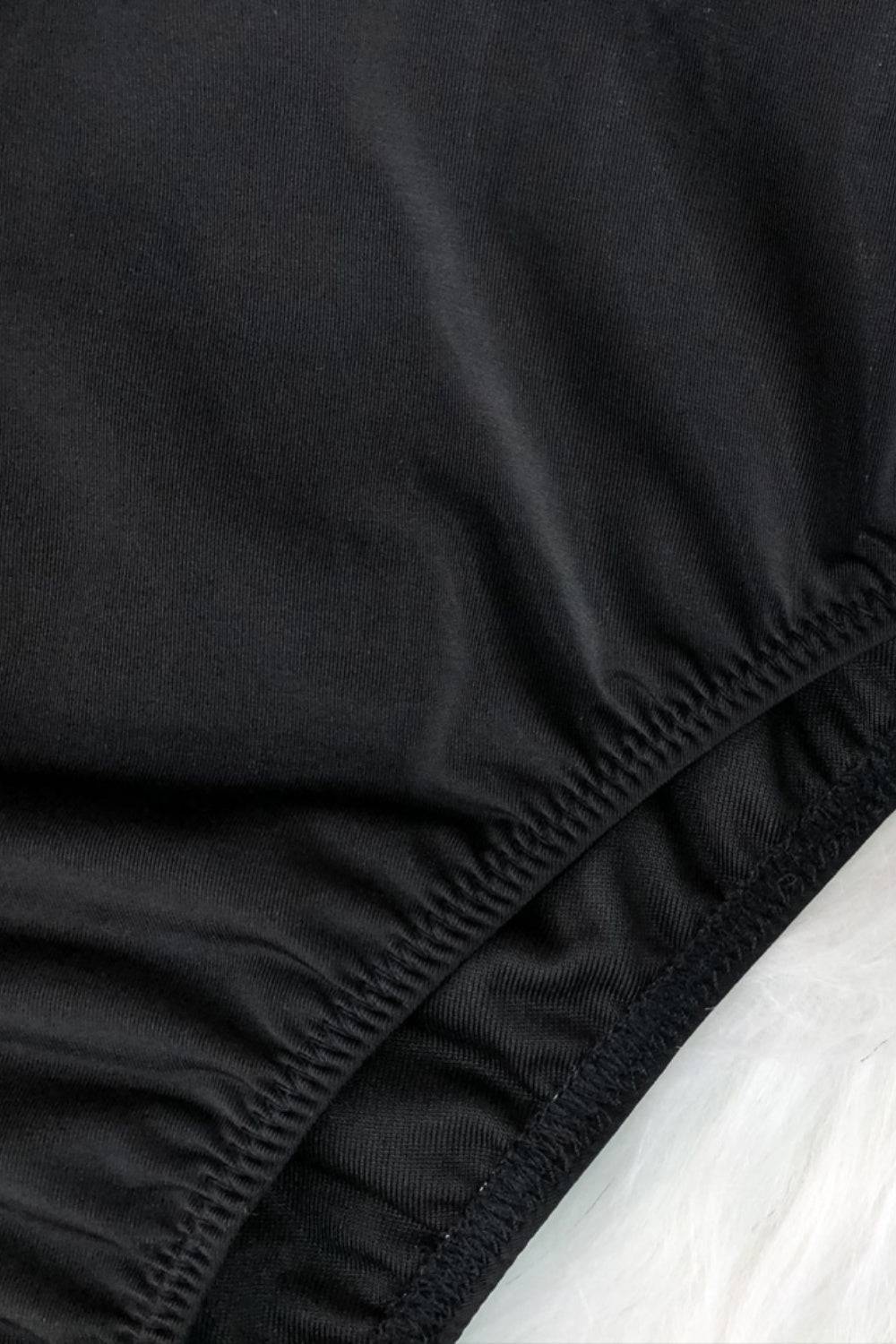 Elastic detail on black swimsuit fabric