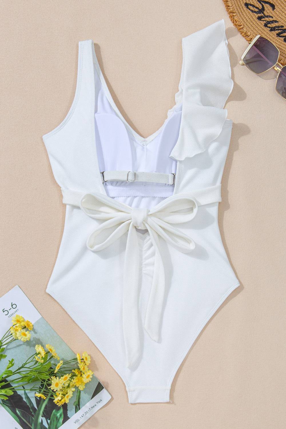 Back detail of white one-piece swimwear with bow