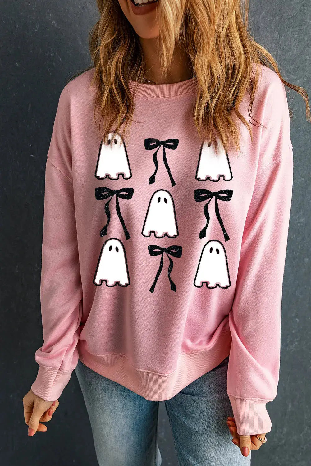 Front view of pink sweatshirt featuring ghost and bow pattern.