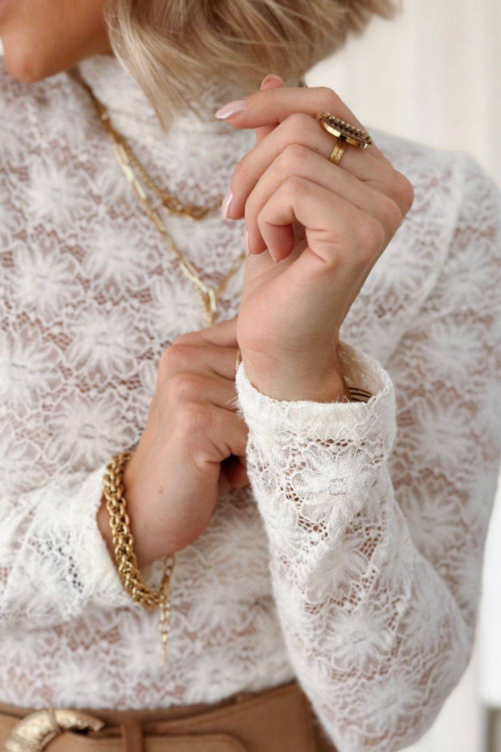 Close-up of white lace fabric with intricate floral design.