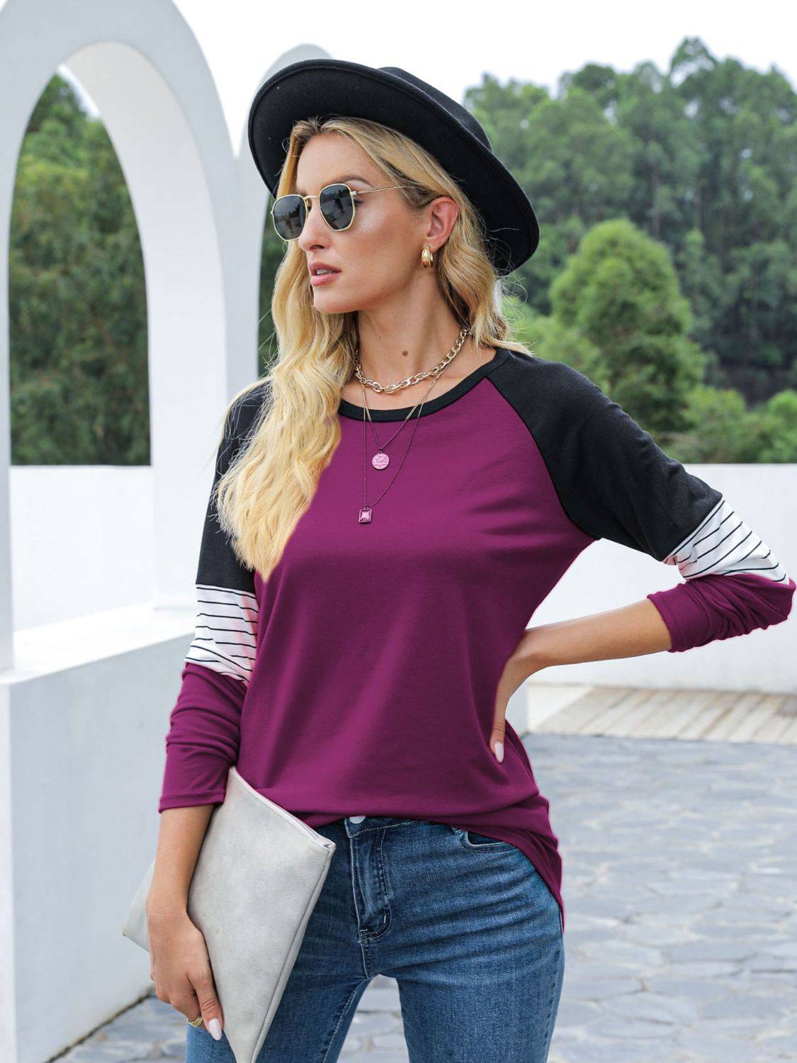 Purple contrast striped T-shirt styled with hat and clutch