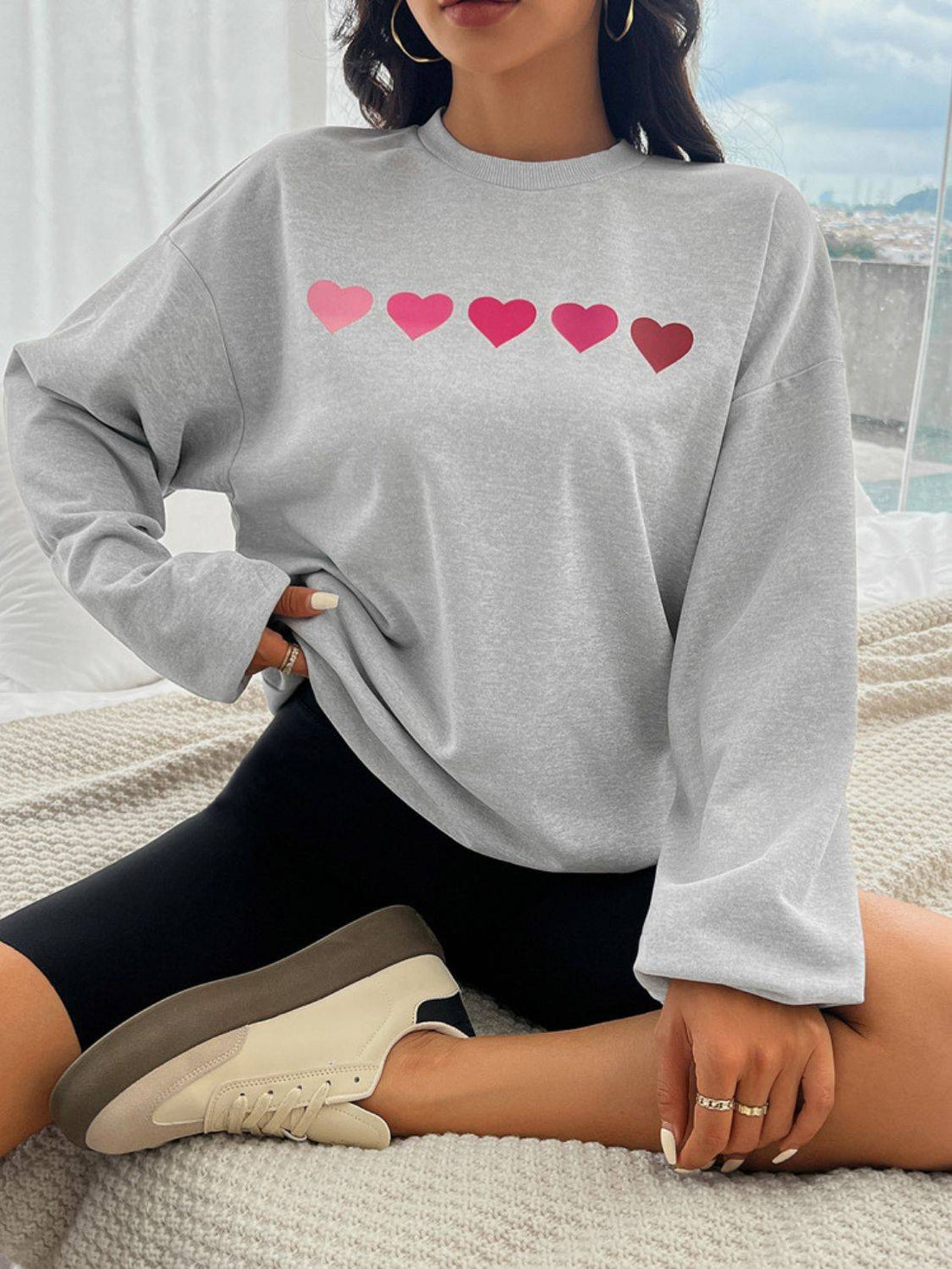 Gray sweatshirt with pink heart design on front.