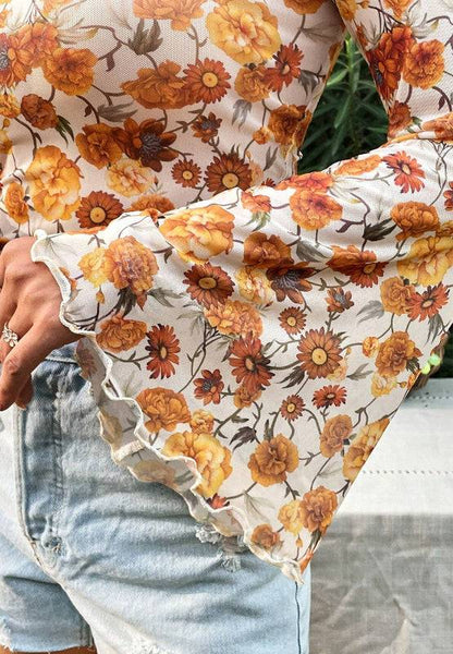 Detail of floral flare sleeve on mock neck top